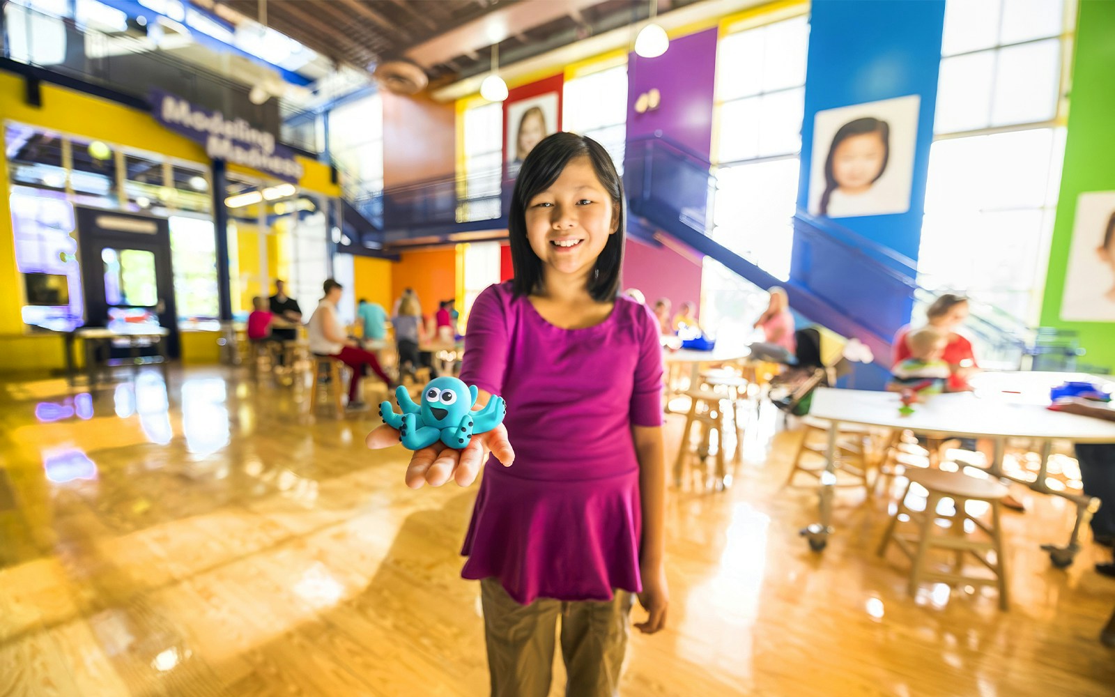 Child holding a blue clay octopus at Crayola Experience in Orlando.