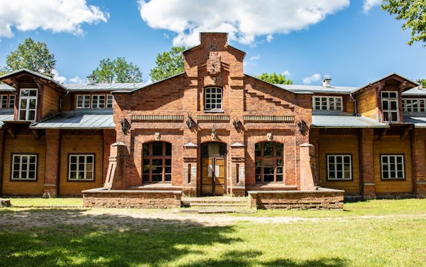 Historic brick building in Bialowieza National Park, Poland, under a clear blue sky.