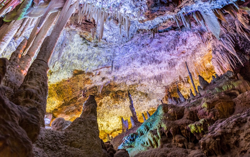 Stalactites and stalagmites inside Hams Caves, Mallorca, with colorful lighting.