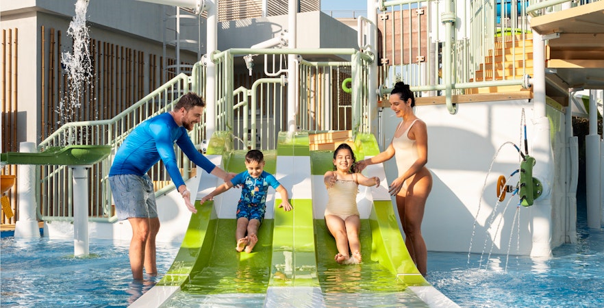 Parents supervising children on water slides at Grand Hyatt waterpark, Dubai.