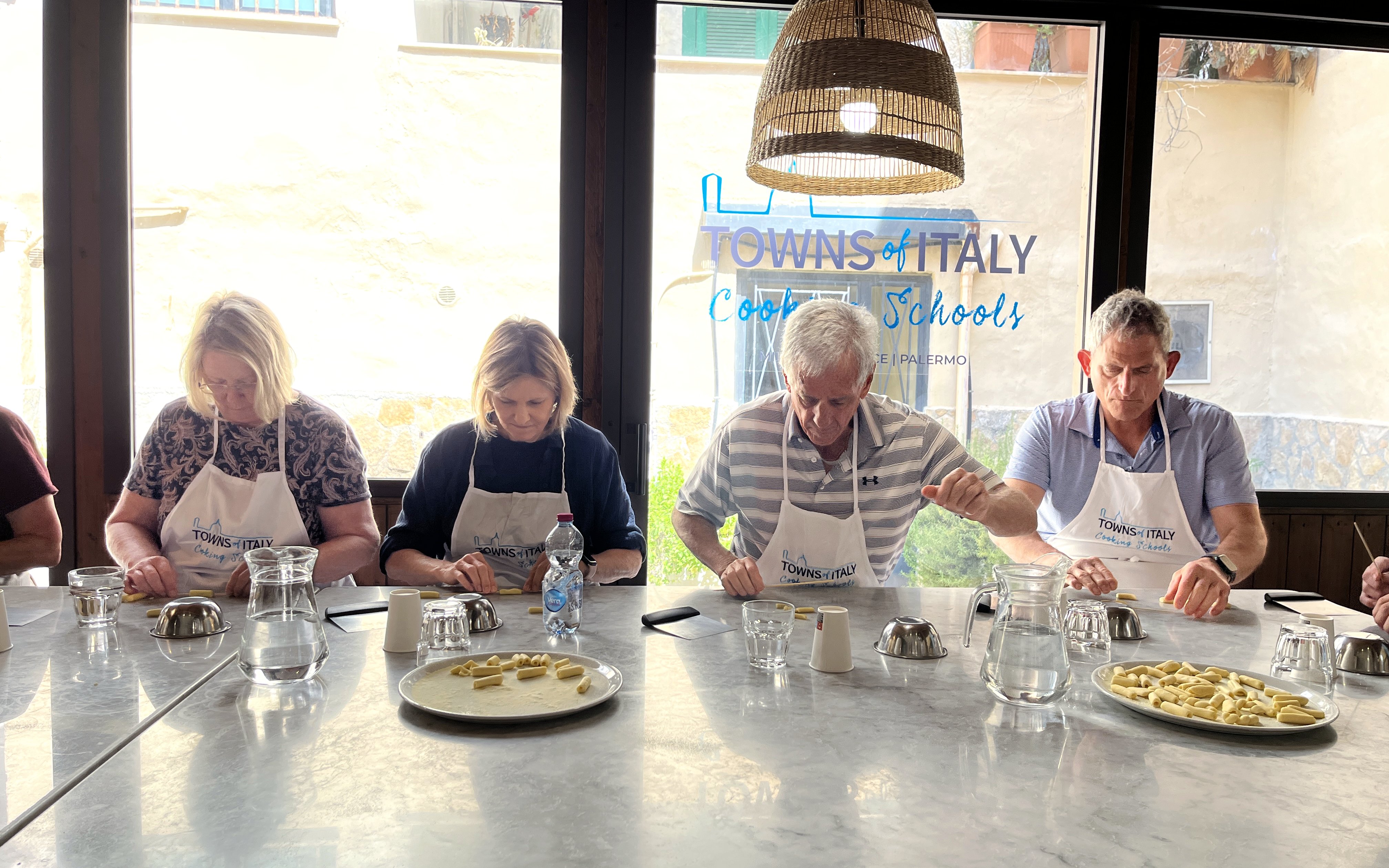 Participants making pasta during Palermo Market Tour and Cooking Class in Italy.