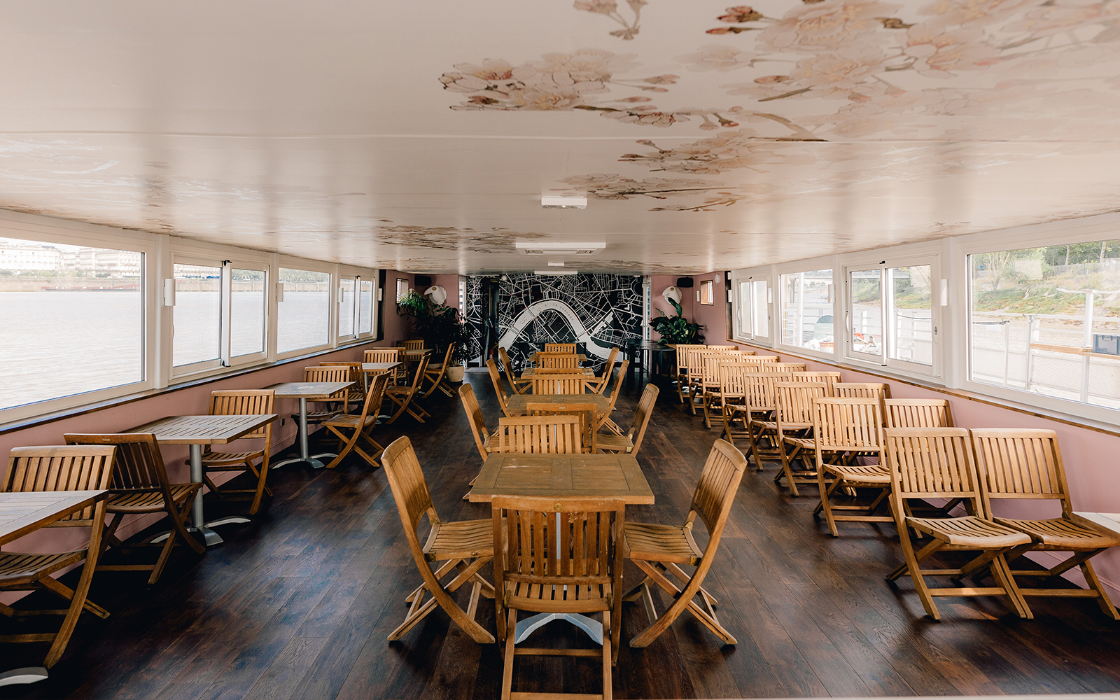 Interior seating area of Bordeaux River Cruise with wooden tables and chairs.
