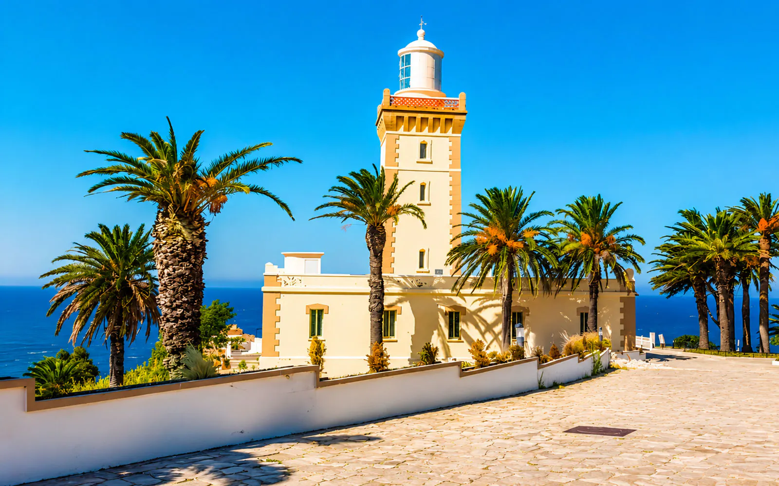 Cap Spartel lighthouse with palm trees and ocean view in Tangier, Morocco.