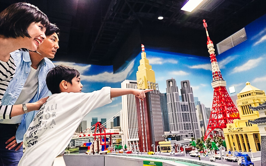 Family exploring LEGO Tokyo skyline at LEGOLAND Discovery Center Tokyo.