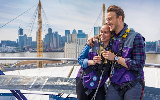 Participants enjoy champagne atop The O2 Arena with London skyline in the background.