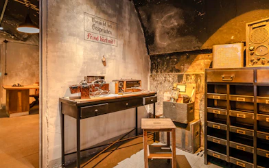 Underground communication room exhibit at Caen Memorial Museum, France, showcasing WWII artifacts.