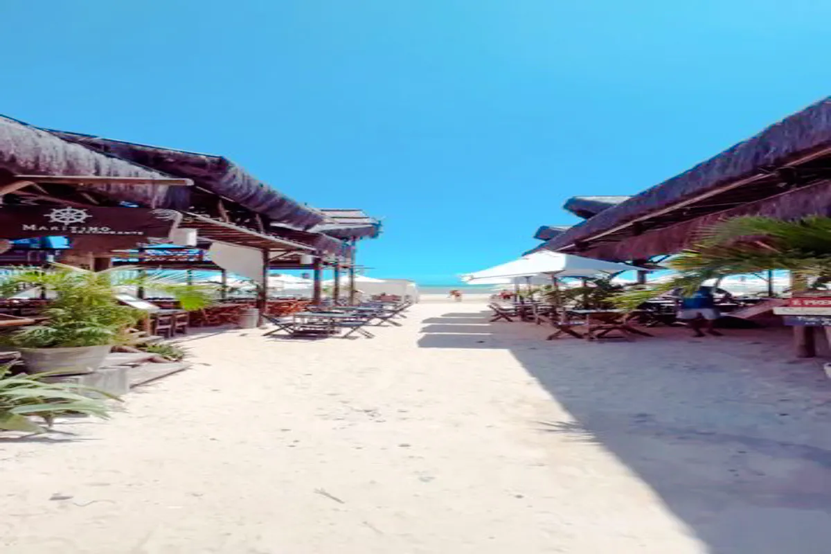 Beachside dining area with tables and umbrellas leading to Flecheiras beach, Sao Paulo.