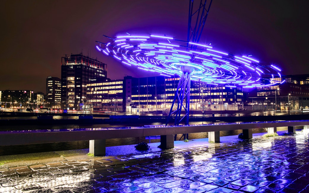 Amsterdam Light Festival installation glowing over canal during small-group cruise.