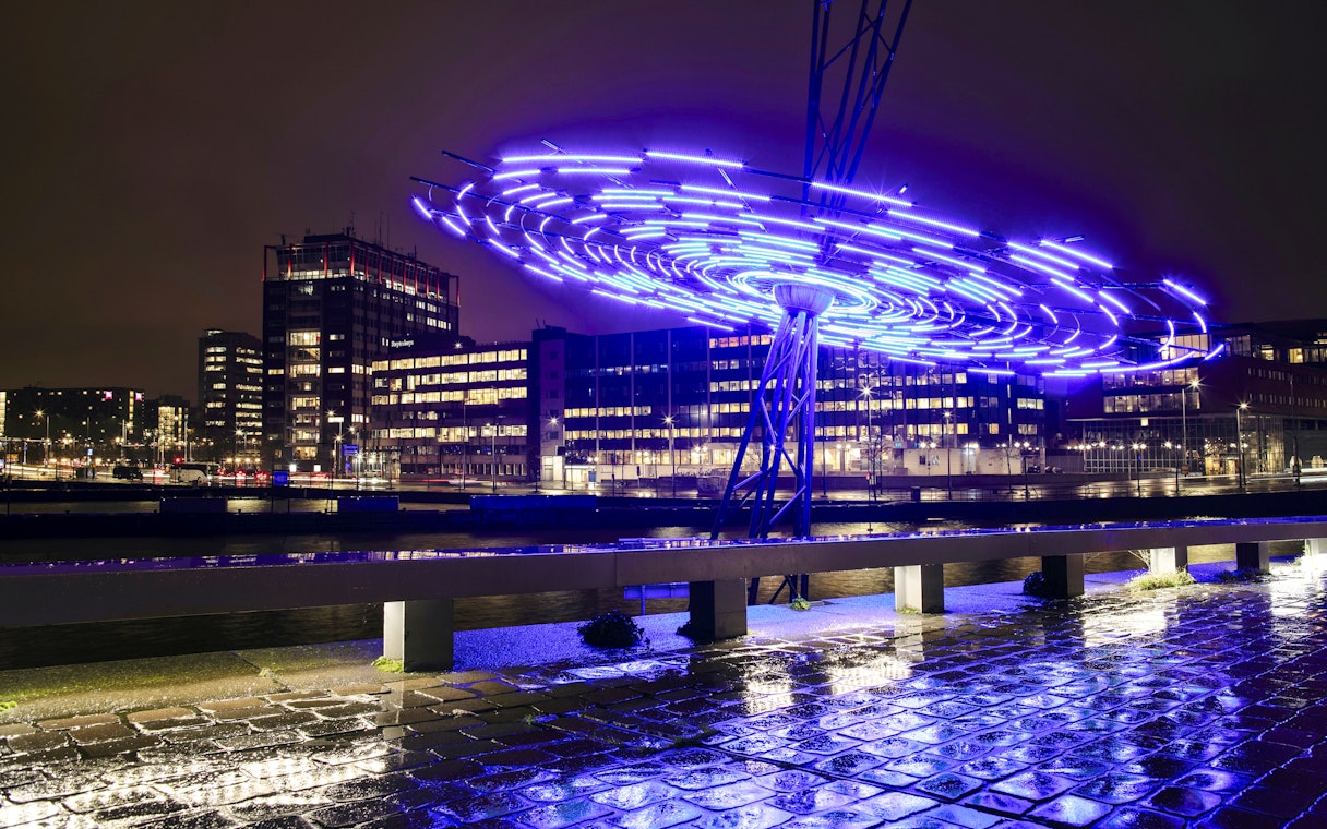 Amsterdam Light Festival installation glowing over canal during small-group cruise.