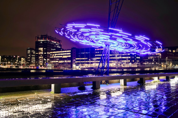 Amsterdam Light Festival installation glowing over canal during small-group cruise.