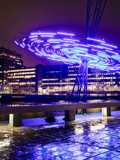 Amsterdam Light Festival installation glowing over canal during small-group cruise.