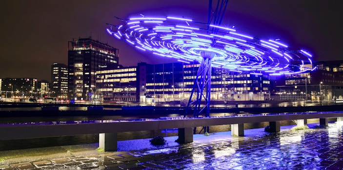 Amsterdam Light Festival installation glowing over canal during small-group cruise.