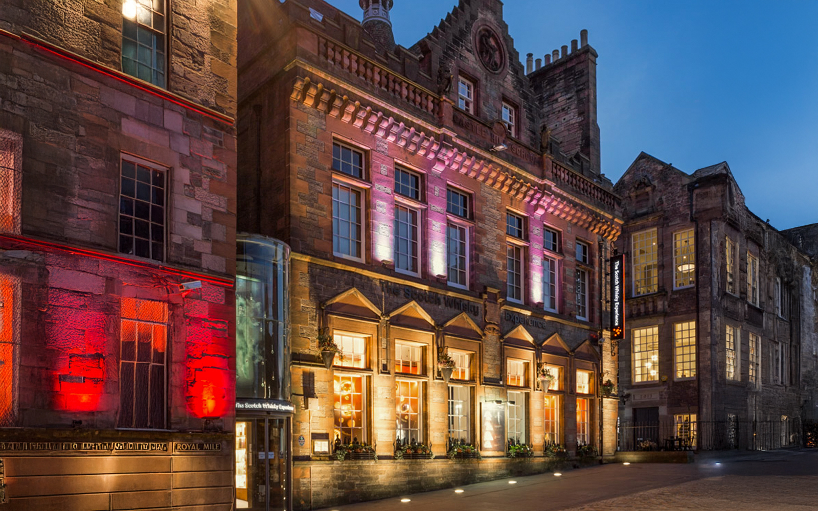 Exteriors of the Scotch Whisky Experience in Edinburgh illuminated at night.