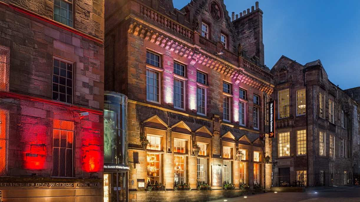 Exteriors of the Scotch Whisky Experience in Edinburgh illuminated at night.