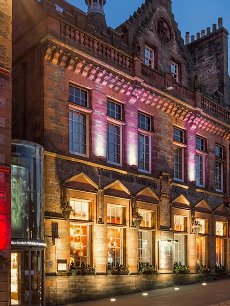 Exteriors of the Scotch Whisky Experience in Edinburgh illuminated at night.