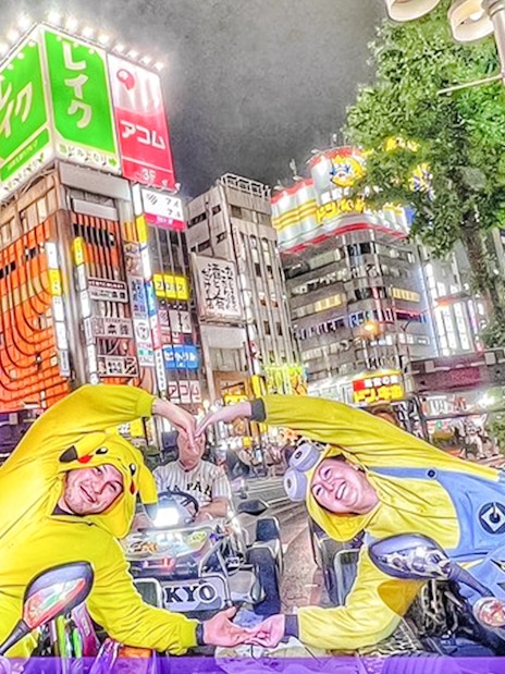 Participants in character costumes on go-karts in Tokyo's vibrant cityscape.