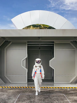 Astronaut walking out of a futuristic building at Lof Land.