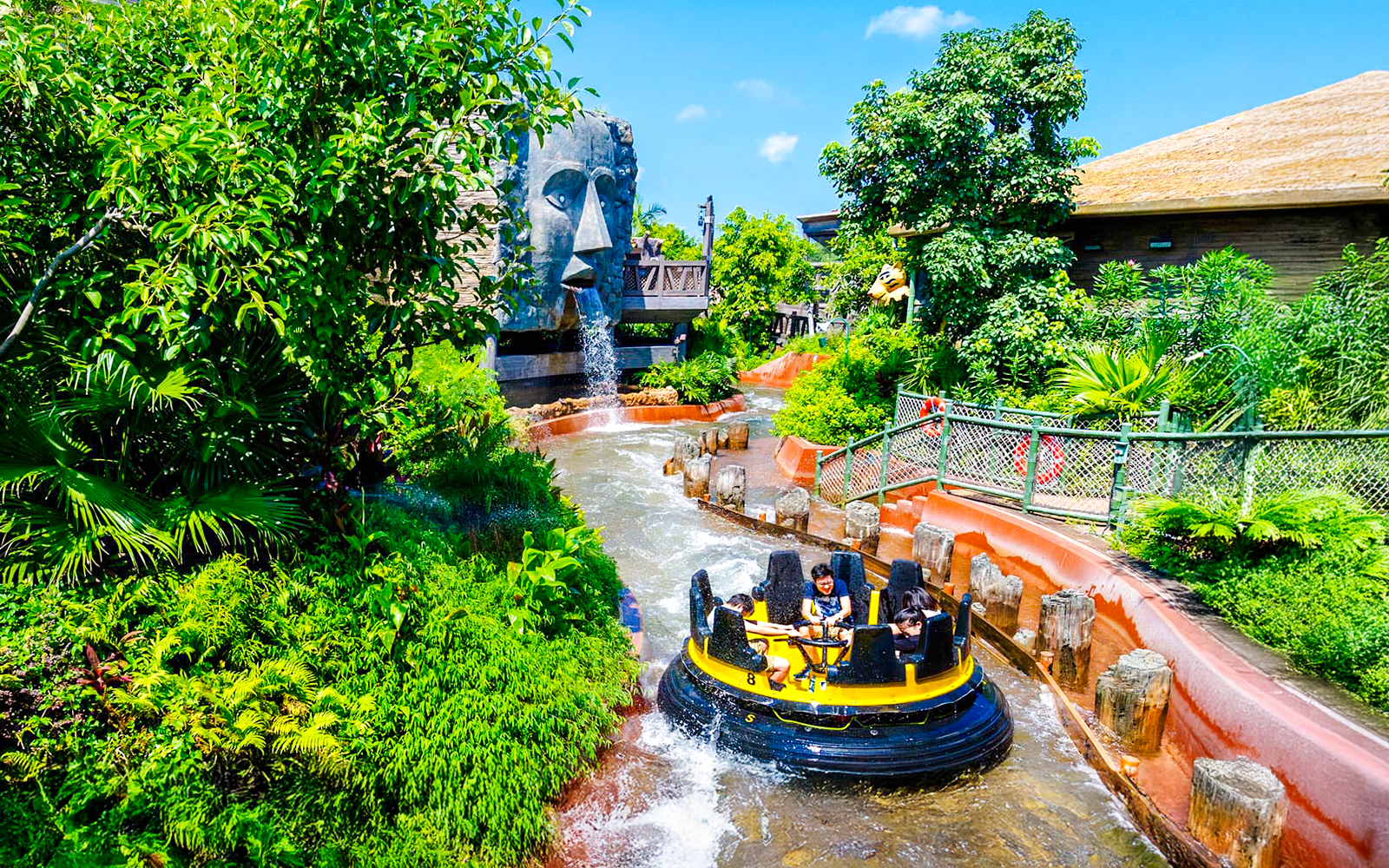 Raft on The Rapids ride at Ocean Park Hong Kong with waterfall and lush greenery.