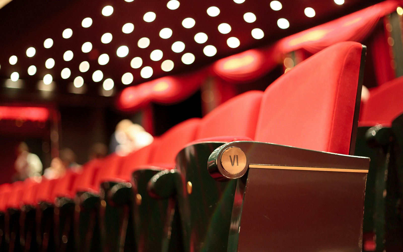 Sseating at LeFrak Theater with red velvet chairs and illuminated ceiling