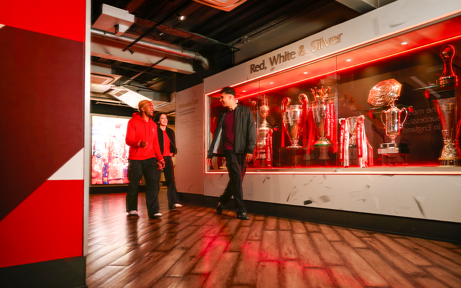 Guests touring Liverpool Football Club Museum trophy display.