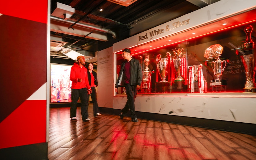 Guests touring Liverpool Football Club Museum trophy display.