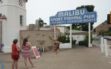 Malibu Sport Fishing Pier entrance with tourists, part of Santa Monica to Malibu tour.