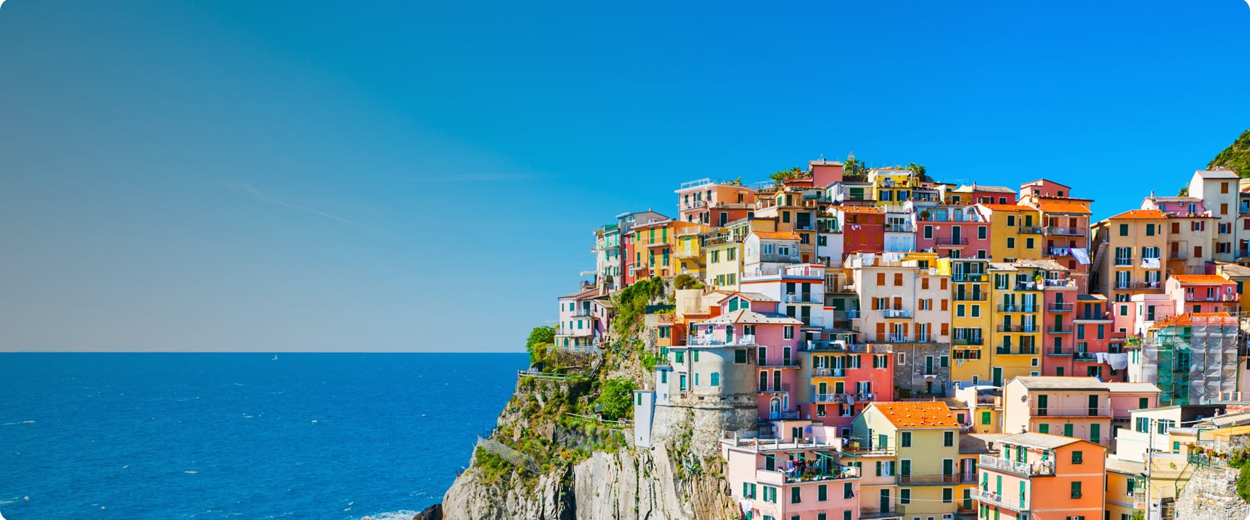 Colorful buildings on a cliffside in Manarola, Cinque Terre, overlooking the sea.