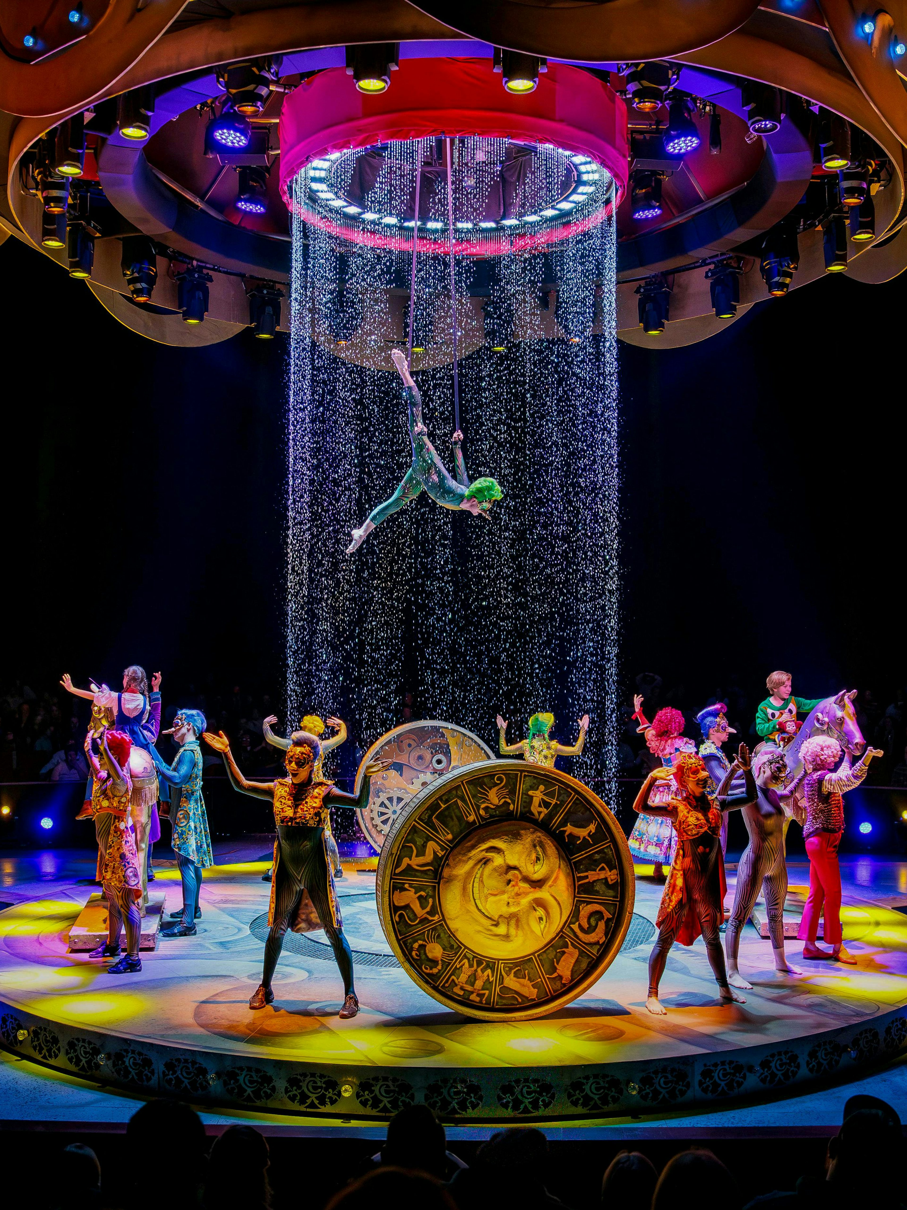 Performers on stage during CARO Theatre Show at Efteling Amsterdam with acrobat suspended above.