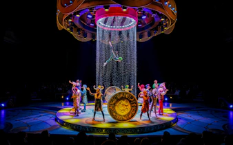 Performers on stage during CARO Theatre Show at Efteling Amsterdam with acrobat suspended above.