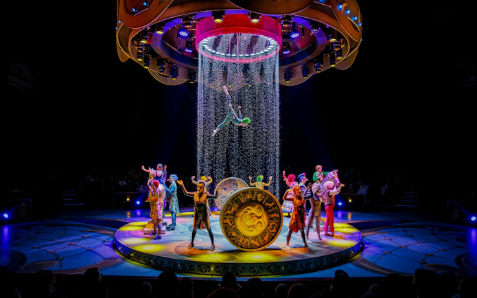 Performers on stage during CARO Theatre Show at Efteling Amsterdam with acrobat suspended above.