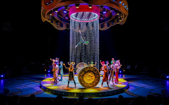 Performers on stage during CARO Theatre Show at Efteling Amsterdam with acrobat suspended above.