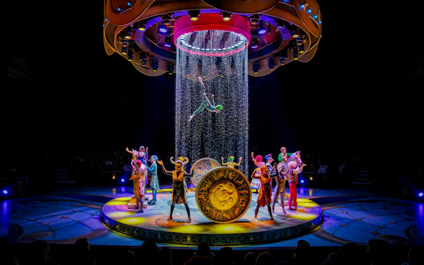 Performers on stage during CARO Theatre Show at Efteling Amsterdam with acrobat suspended above.