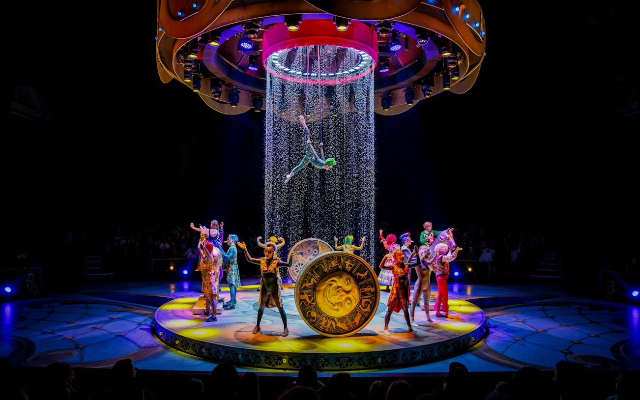 Performers on stage during CARO Theatre Show at Efteling Amsterdam with acrobat suspended above.