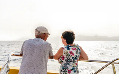 Tourists enjoying sunset views on a speedboat during a dolphin cruise.