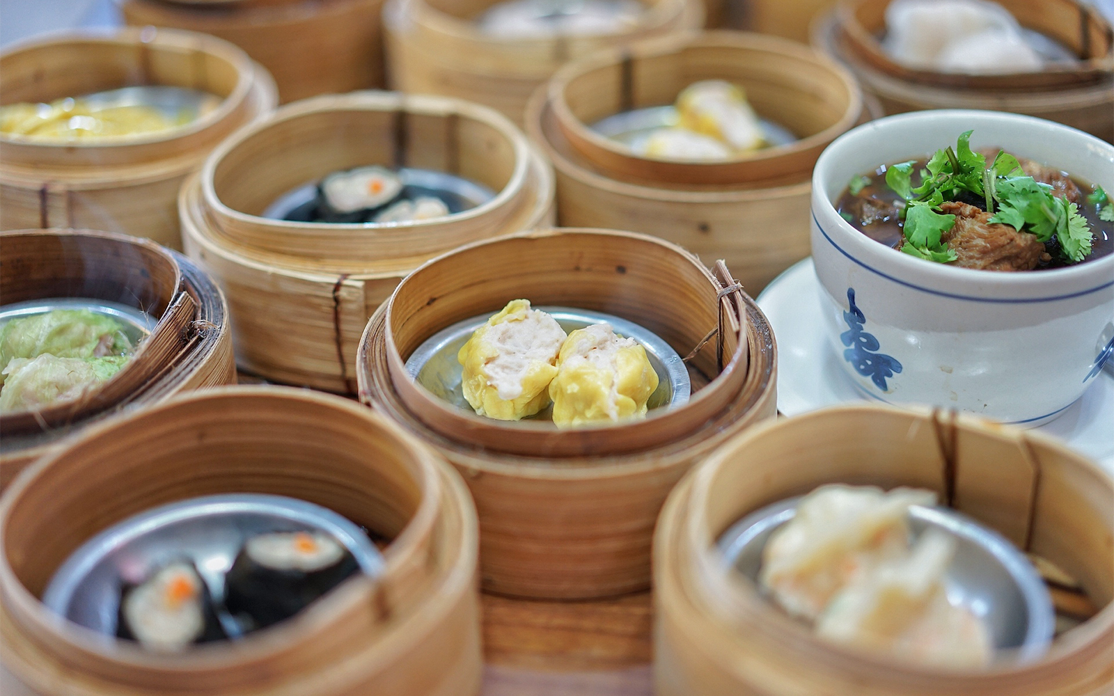 Dim sum baskets and a bowl of soup on a table during a Phuket guided tour.