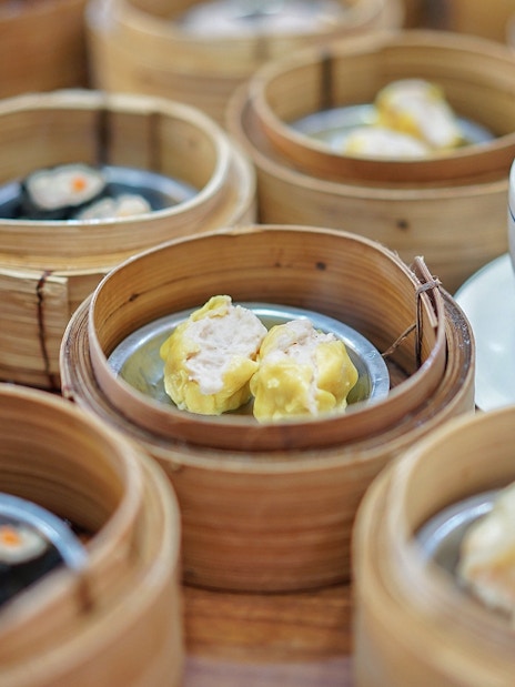 Dim sum baskets and a bowl of soup on a table during a Phuket guided tour.