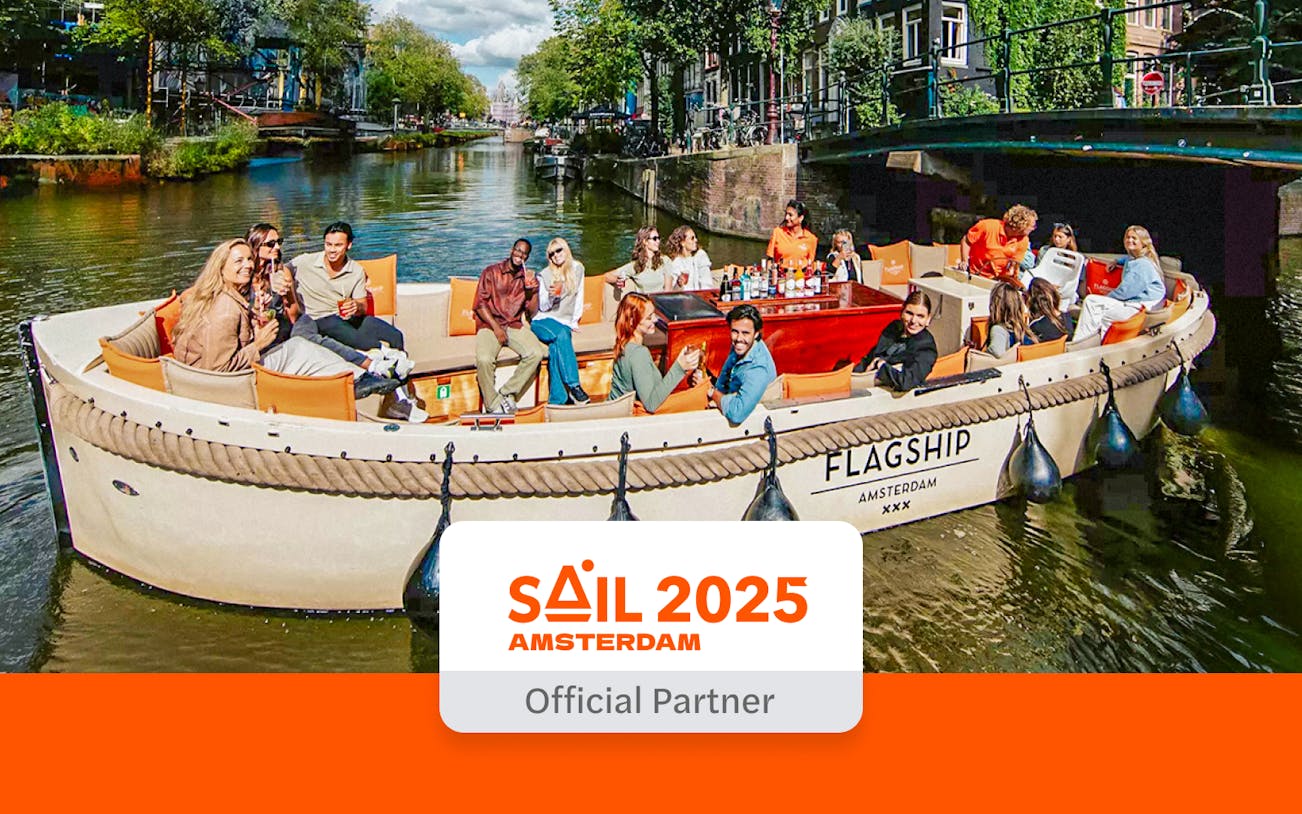 Luxury open boat cruising through Amsterdam canals with passengers enjoying drinks.
