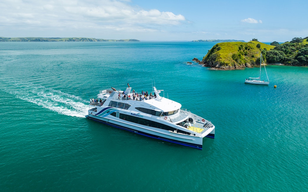 Ferry traveling to Waiheke Island across turquoise waters with passengers on deck.