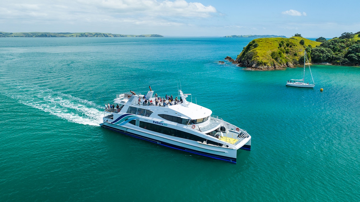 Ferry traveling to Waiheke Island across turquoise waters with passengers on deck.