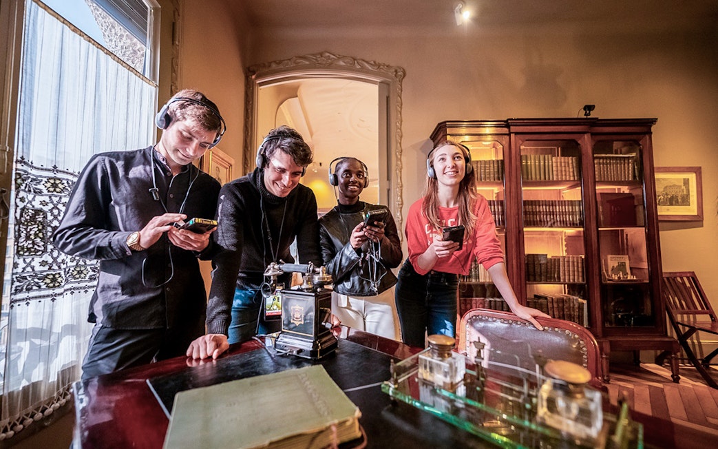 Visitors using audio guides at La Pedrera-Casa Milà in Barcelona.