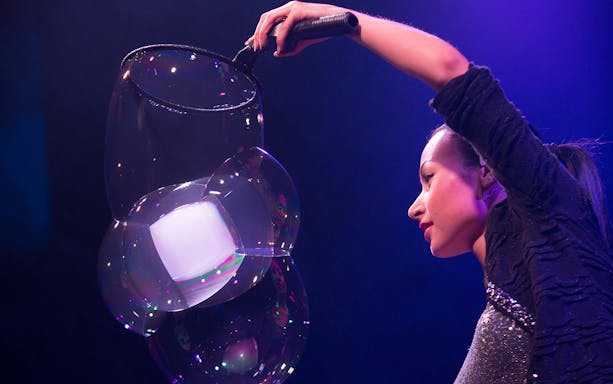 Performer creating large bubbles at The Gazillion Bubble Show.