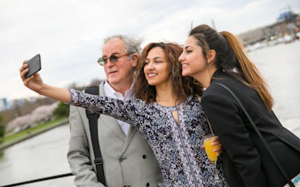 Guests taking a selfie on the deck of the Signature Bottomless Mimosa Brunch Cruise in Washington DC.