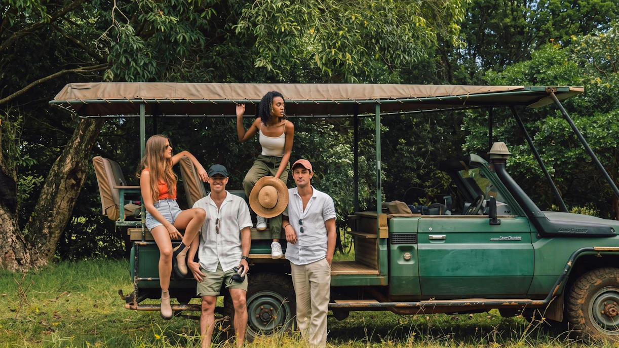 Group enjoying a 4x4 safari in Bel Ombre, standing by an open-top vehicle in lush greenery.