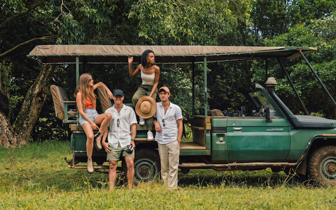 Group enjoying a 4x4 safari in Bel Ombre, standing by an open-top vehicle in lush greenery.