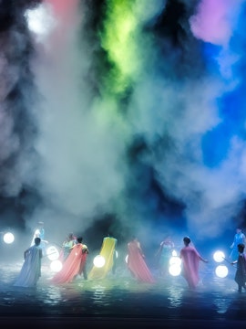 Performers with glowing spheres amidst mist at Encore Melaka.