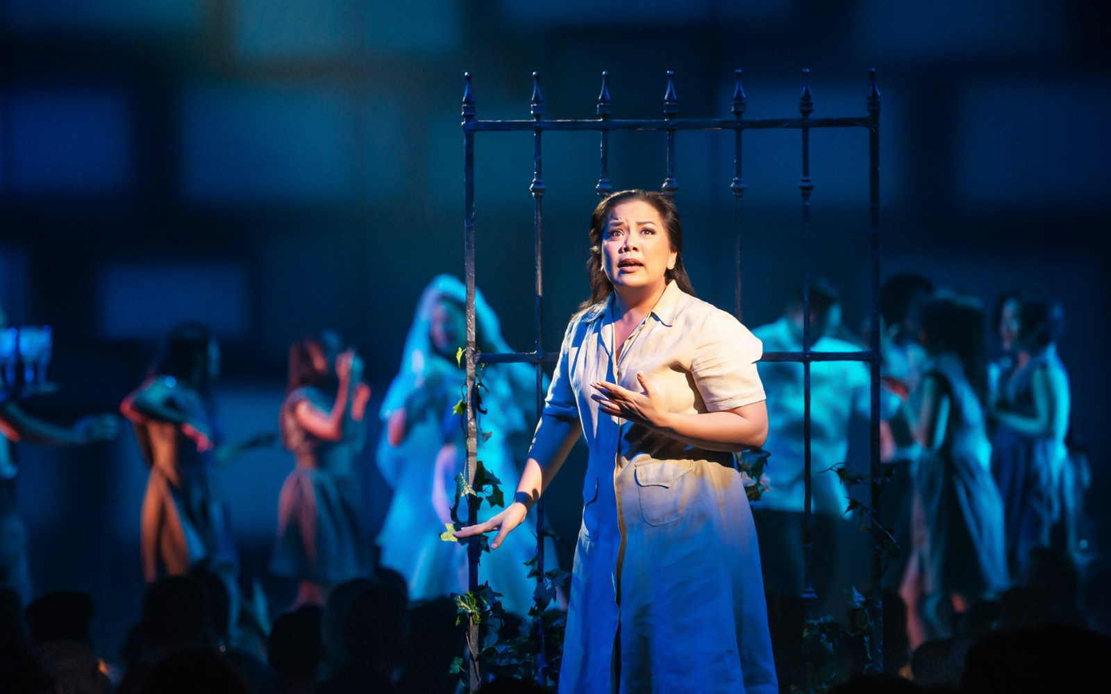 Performer on stage during "Here Lies Love" musical scene.