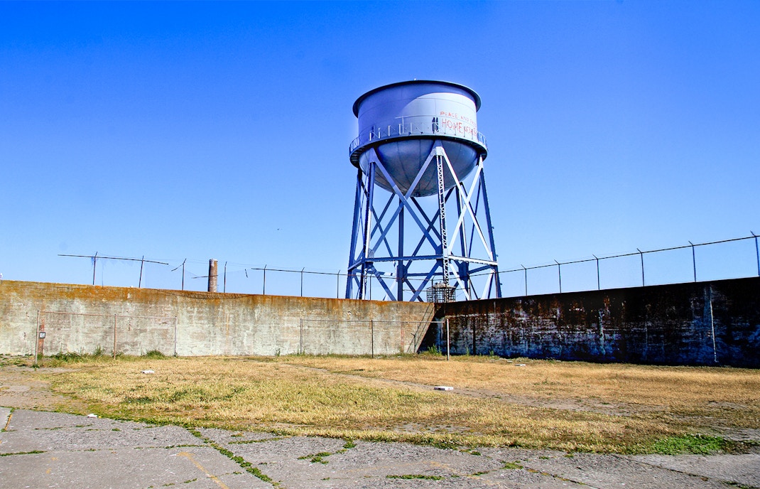 Water tower at Alcatraz Island, San Francisco, with blue sky background.