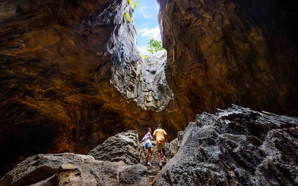 Visitors exploring a cavern in the Rainforest Wild, Asia.