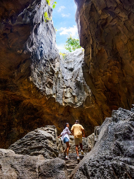 Visitors exploring a cavern in the Rainforest Wild, Asia.