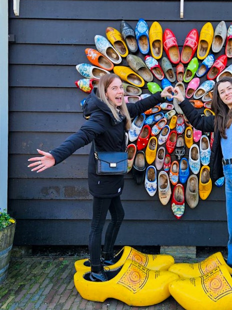 Guests posing with colorful clogs at Zaanse Schans, Netherlands.